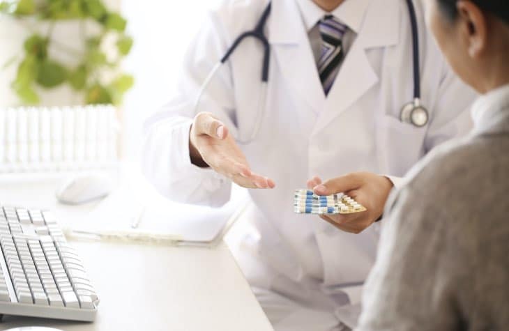 Doctor handing client medication to be used for treatment