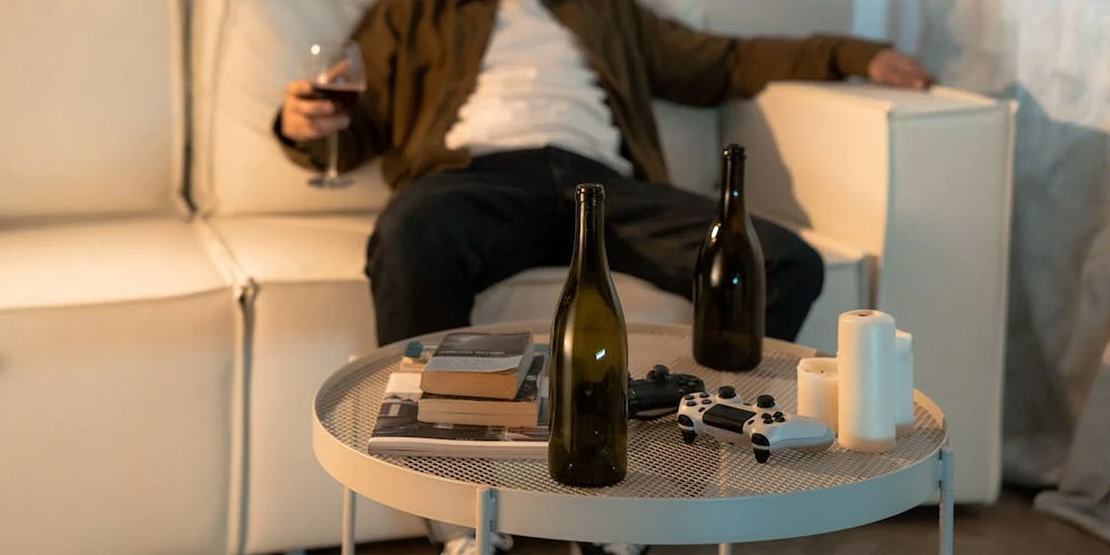 person sitting on a couch with alcohol in front
