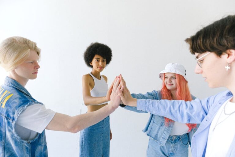 smiling group of teenager friends with hands stacked