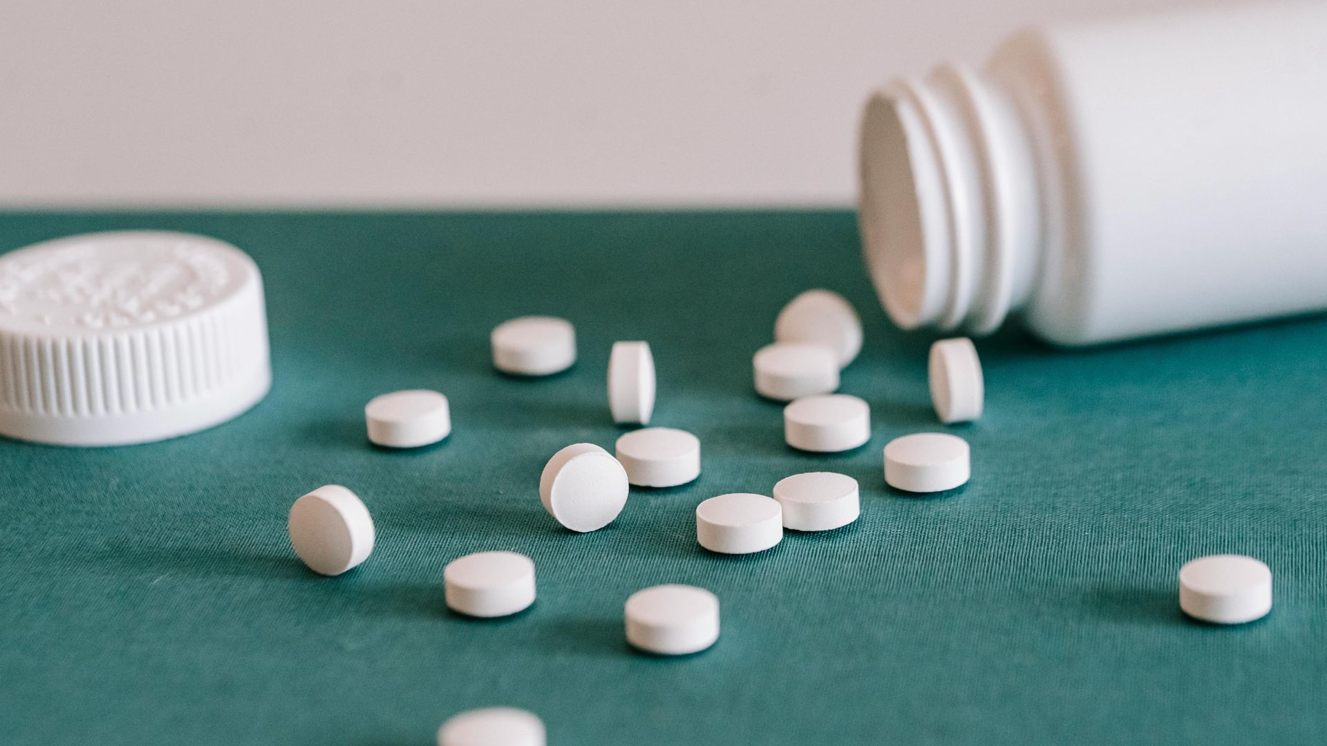 pills spilled out of white jar