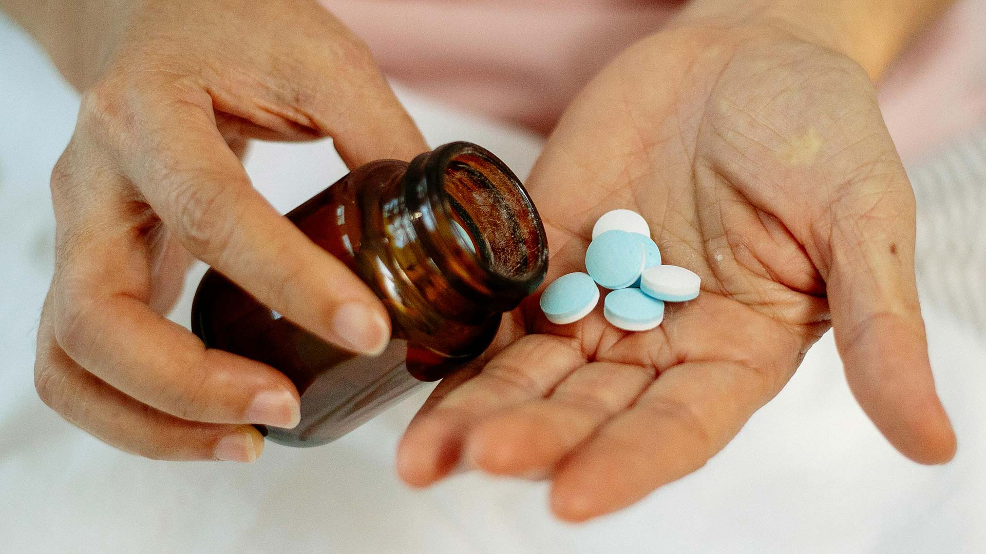 female with pills in hand and bottle