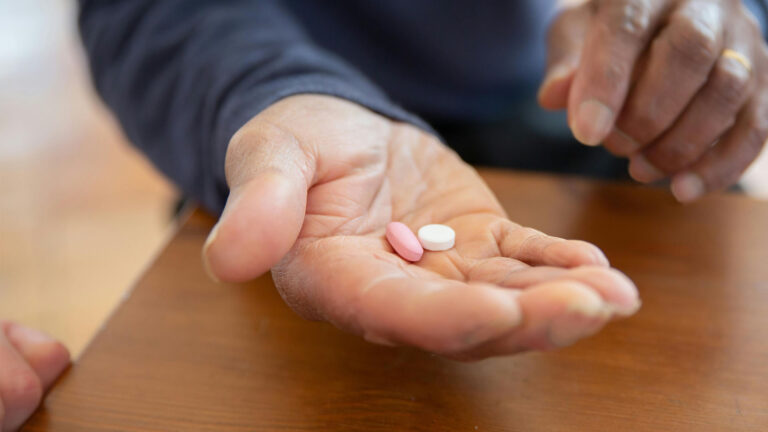 man holding two pills