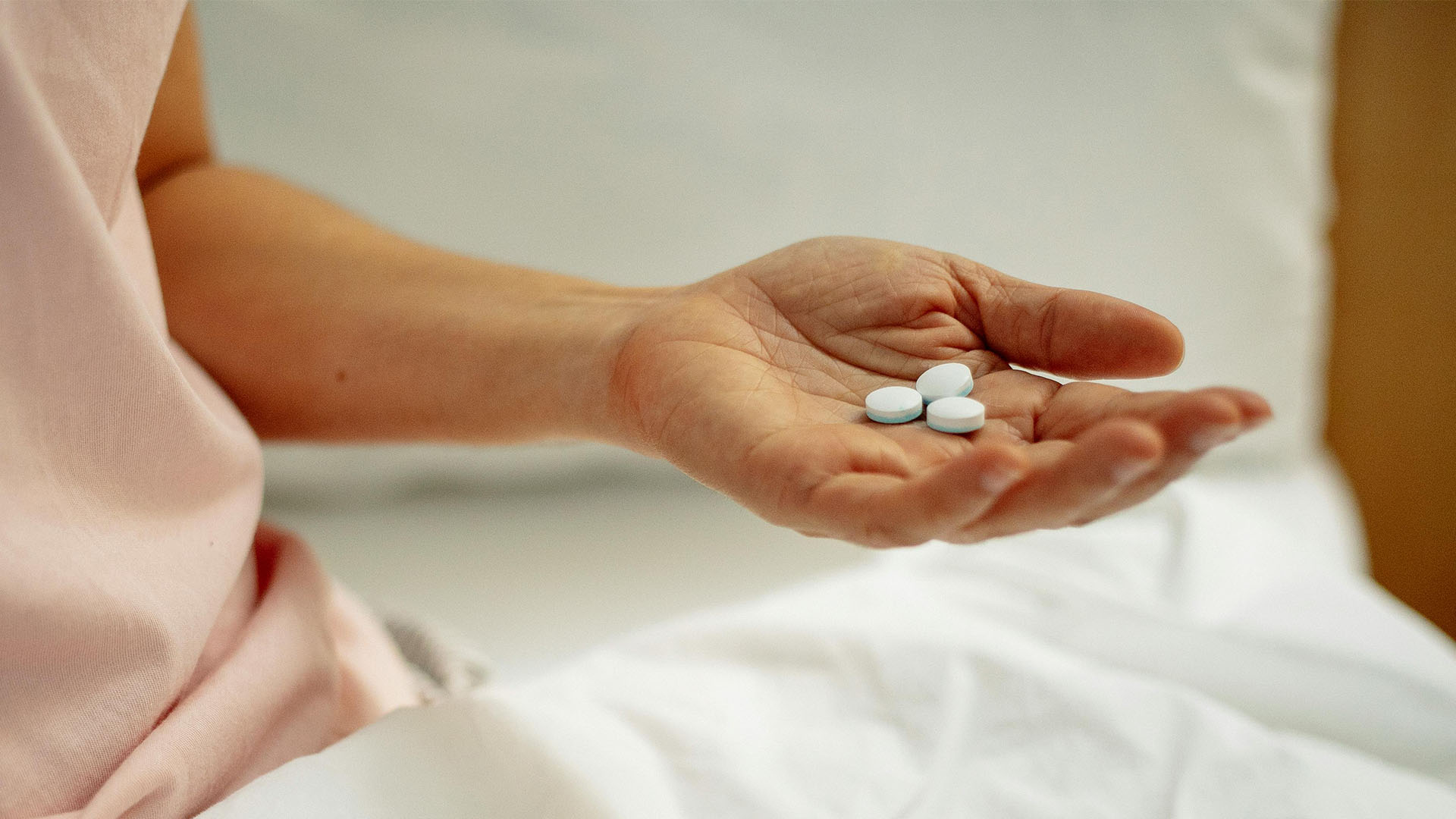 woman preparing for taking white pill in hand