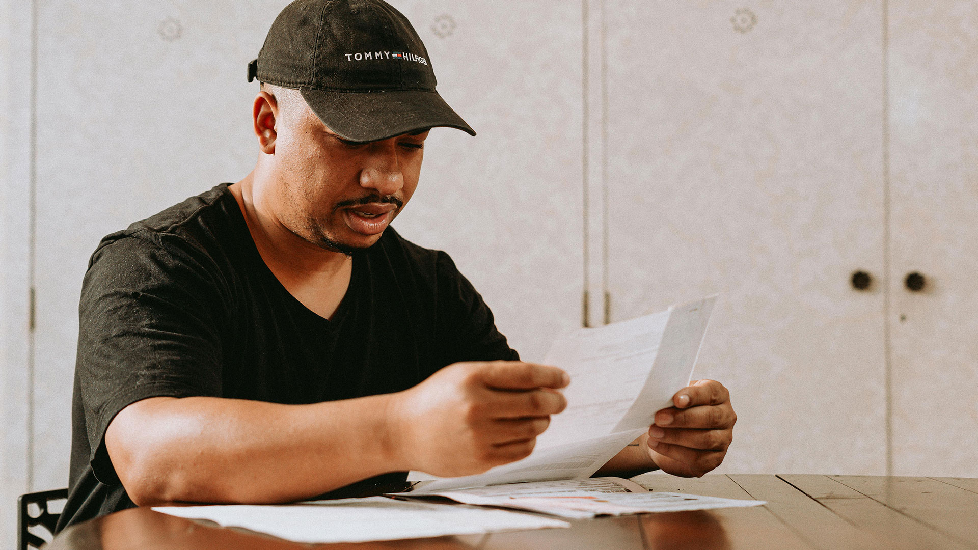 man holding and reading results in a paper