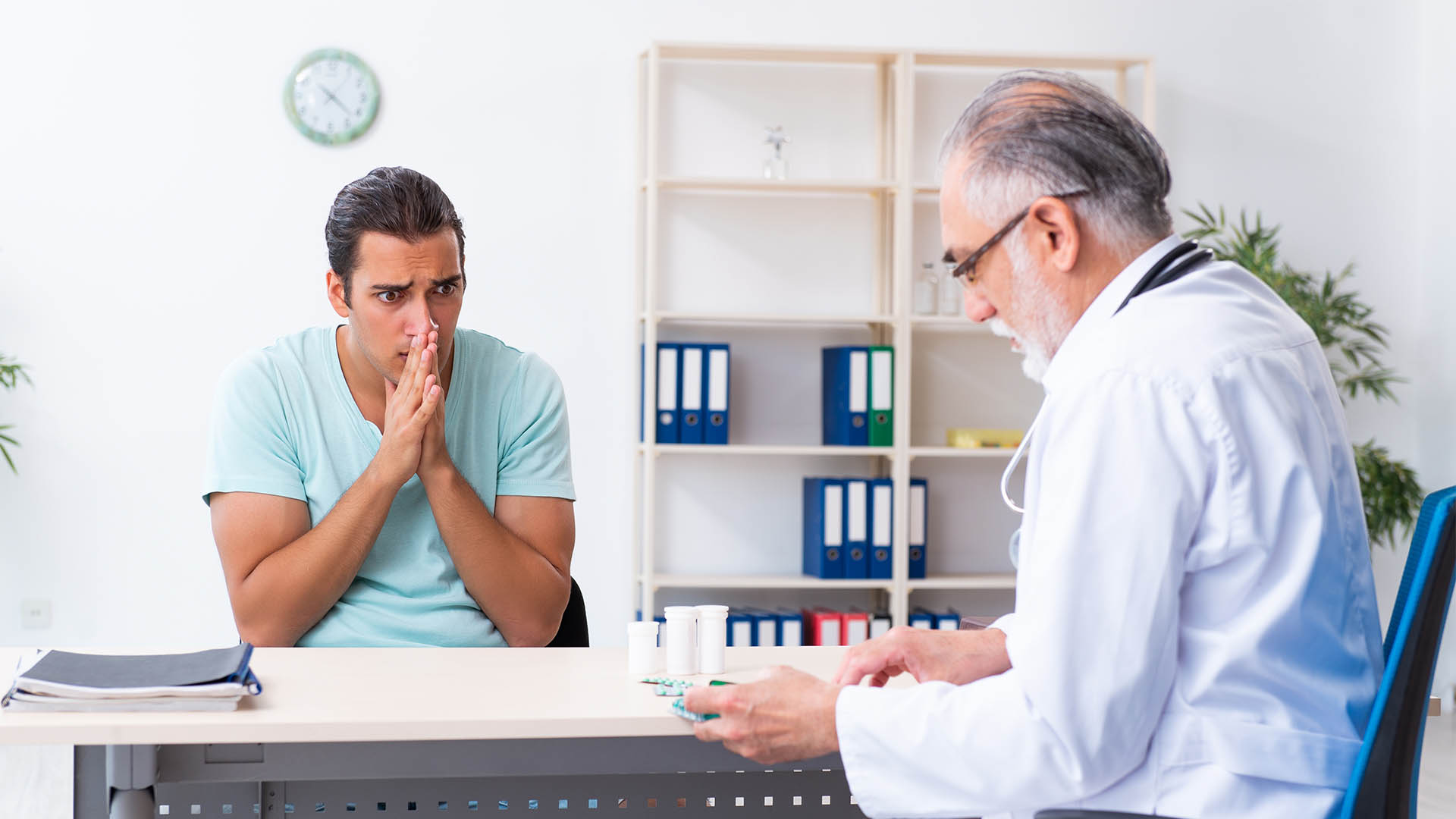 young man visiting old male doctor