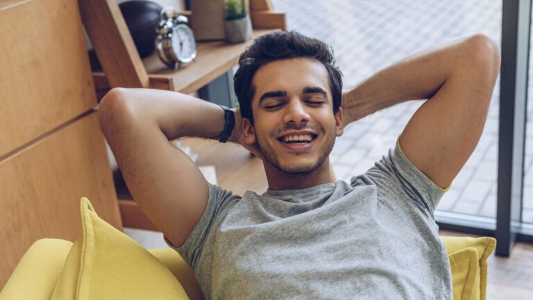 man hands head closed eyes smiling