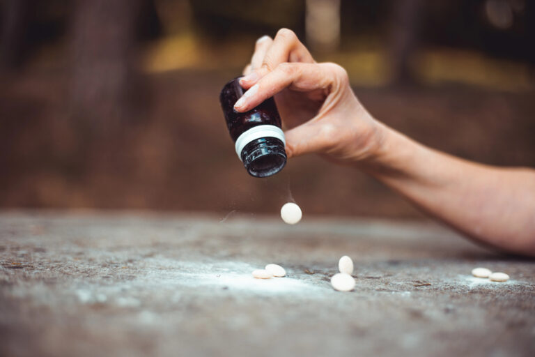 person hand pouring out pills