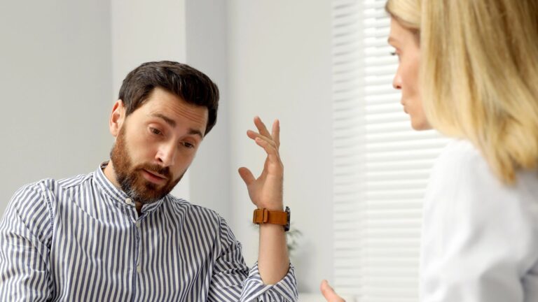 Doctor consulting patient at white table in clinic