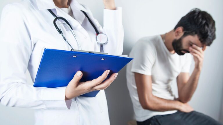 depressed man with woman doctor beside him