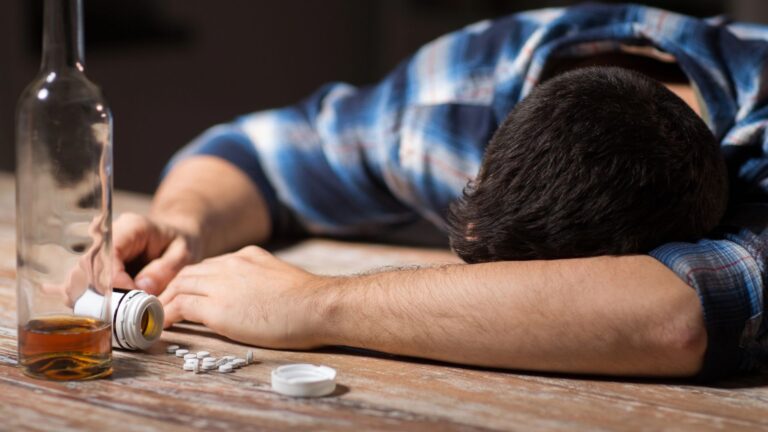 man lying on the table with medication and alcohol
