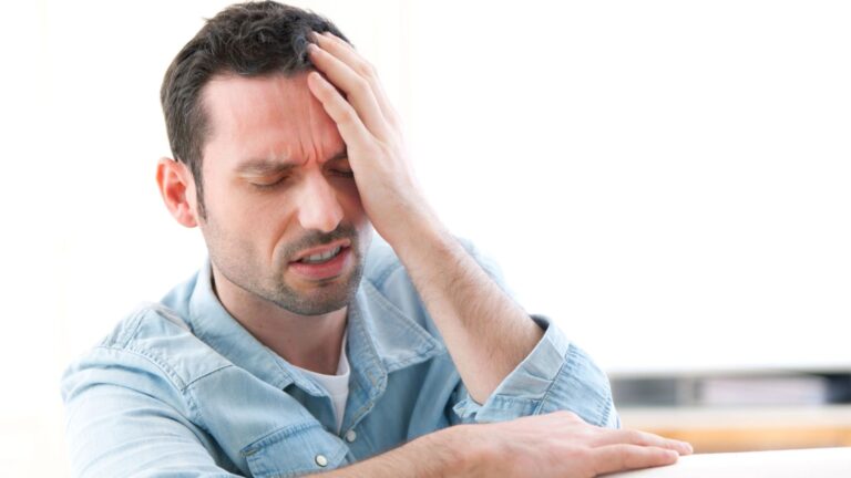 man suffering from headache at work (GHB Street Names)