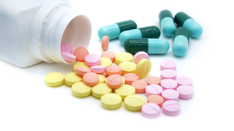 Isolated pills spilling out of pill bottle