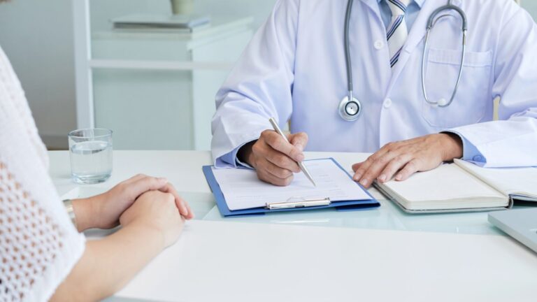 doctor filling medical paper for his female client