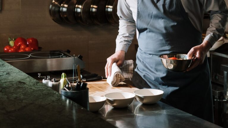 Male chef in a kitchen preparing a dish