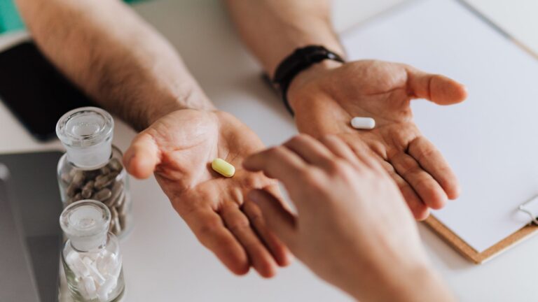hands exchanging pills in a clinical environment