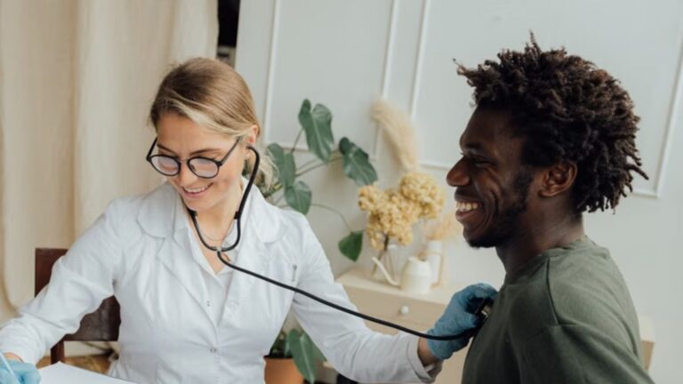 doctor checks black male patient's heart rate