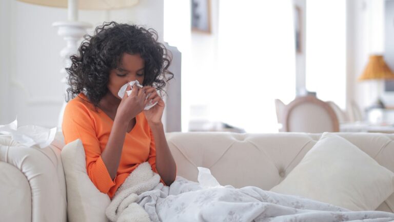 woman wiping her nose with tissue